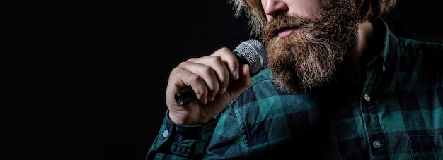 Uomo barbuto al karaoke canta una canzone in un microfono maschio assiste al karaoke uomo con la barba che tiene un microfono e canta