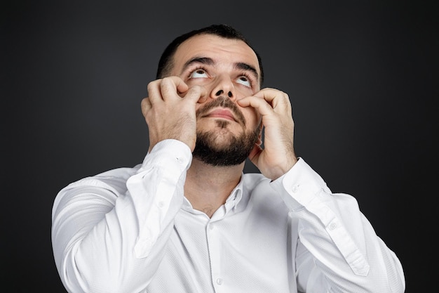 Bearded man keeps hand on head