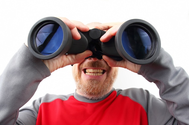 Photo bearded man looking through binoculars on white background