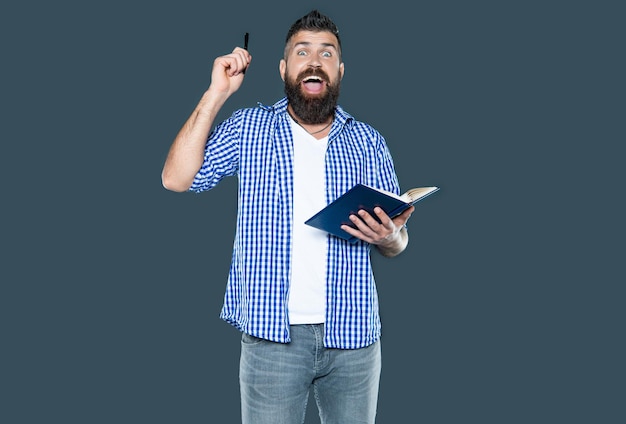 bearded man making notes in book on grey background happiness