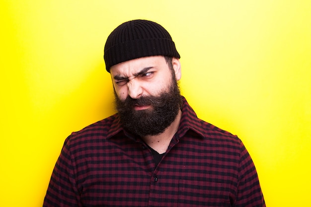 Bearded man making silly faces on yellow background