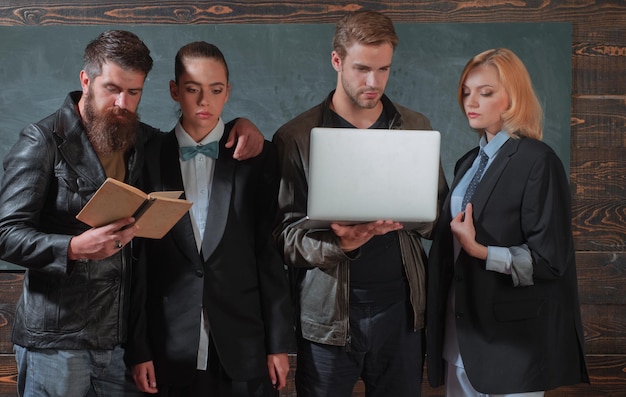 Bearded man masculine girl and handsome guy school colleagues
teaching and education occupation diversity concept school staff
people with laptop book stand in school classroom school
teachers