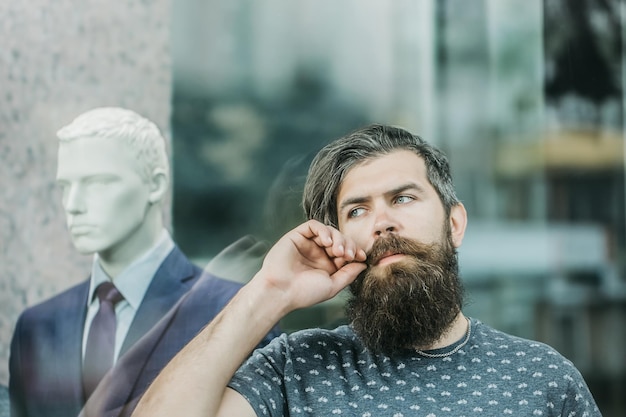 Photo bearded man near showcase with dummy