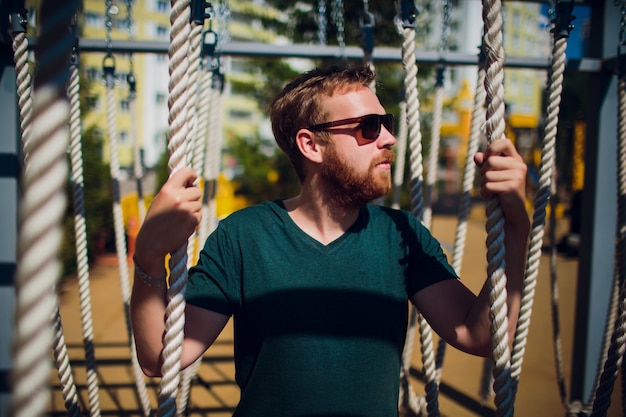 Бородатый мужчина на детской площадке