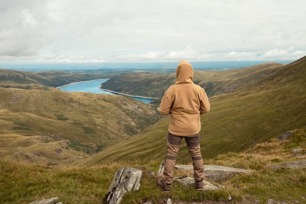 Bearded Man reaching the destination and on the top of a mountain at sunset on autumn day Travel