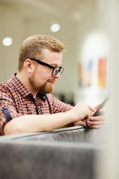 Bearded man reading message on phone