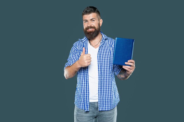 bearded man recommend book on grey background thumb up