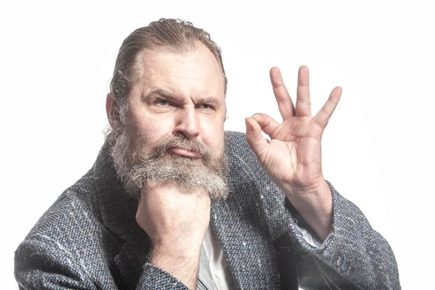 Bearded man rests chin on his fist and shows Okay sign