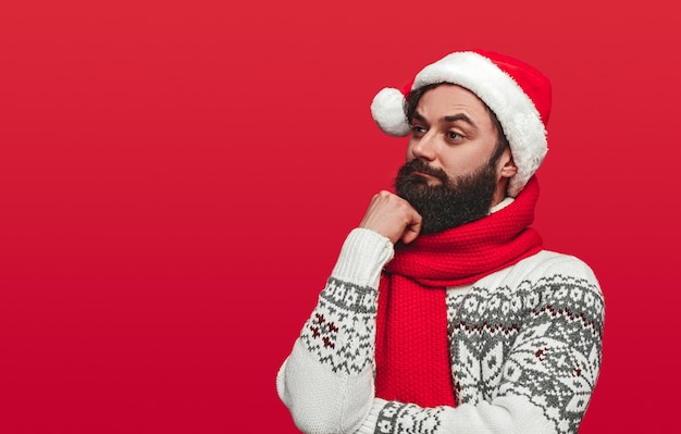 bearded man in Santa hat looking away