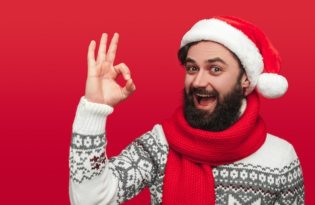 bearded man in Santa hat showing OK gesture