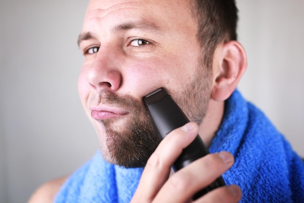 Bearded man shaving electric