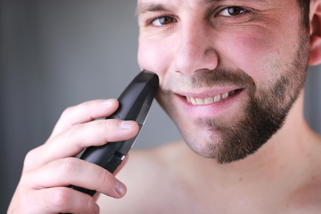 Bearded man shaving electric