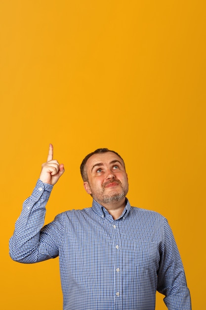 Photo bearded man in shirt points finger up.