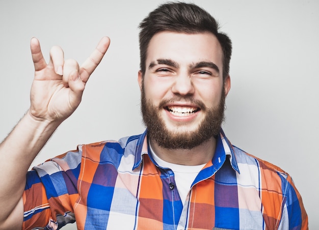 Bearded man showing heavy gesture over grey background