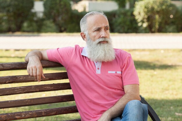 Bearded man sitting on a bench in the park