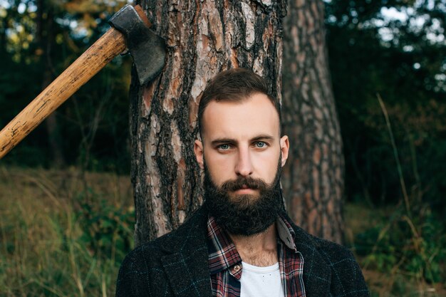 Bearded man sitting close to a tree