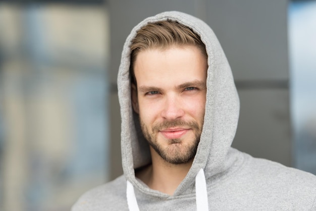 Bearded man smile in hood outdoor Happy sportsman in casual style Ready for workout Training on fresh air Sport and fitness