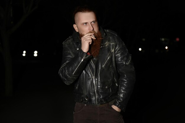 Bearded man smoking weed outdoors late in evening