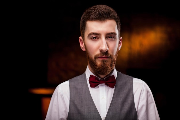 A bearded man sommelier tries white wine in a glass. Close -up portrait of professional sommelier.