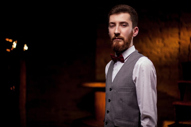 A bearded man sommelier tries white wine in a glass. Close -up portrait of professional sommelier.