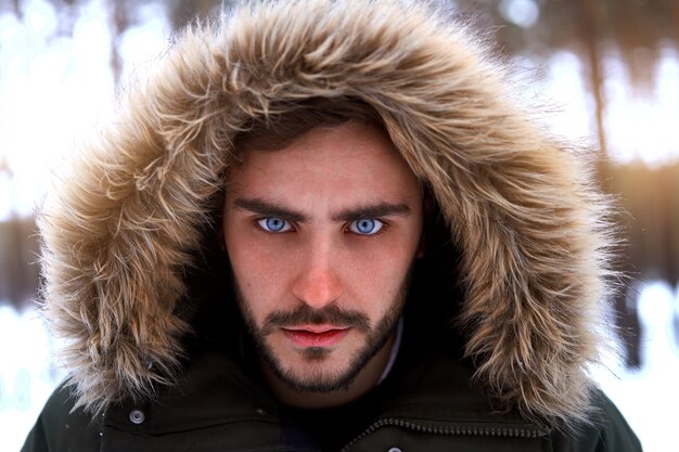 Foto uomo barbuto in piedi all'aperto nella foresta invernale