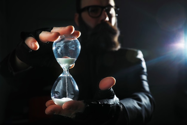 Photo a bearded man in a suit holds an object in his hand. concept of time and ideas. aspiration and development.