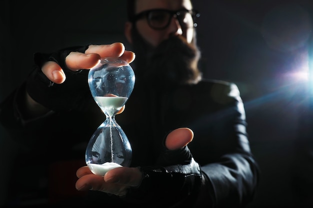 A bearded man in a suit holds an object in his hand. Concept of time and ideas. Aspiration and development.