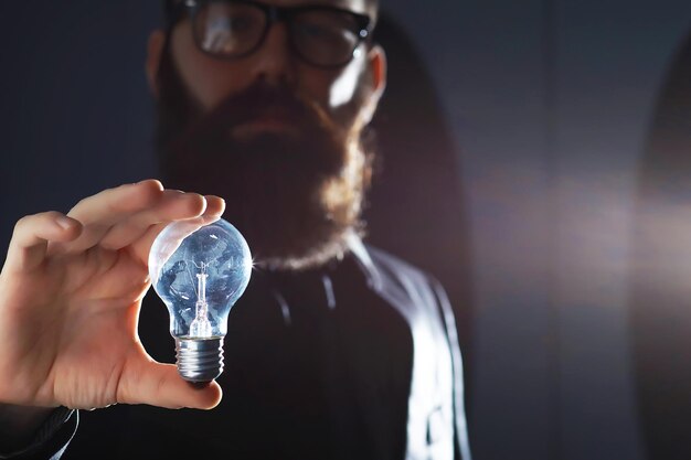 a bearded man in a suit holds an object in his hand concept of time and ideas aspiration and development