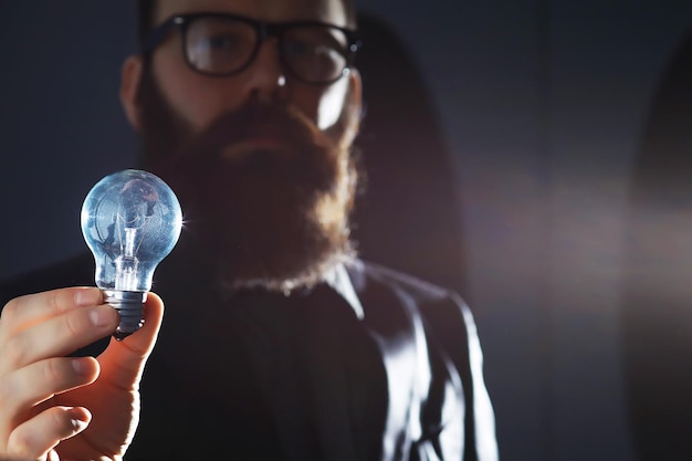 a bearded man in a suit holds an object in his hand concept of time and ideas aspiration and development