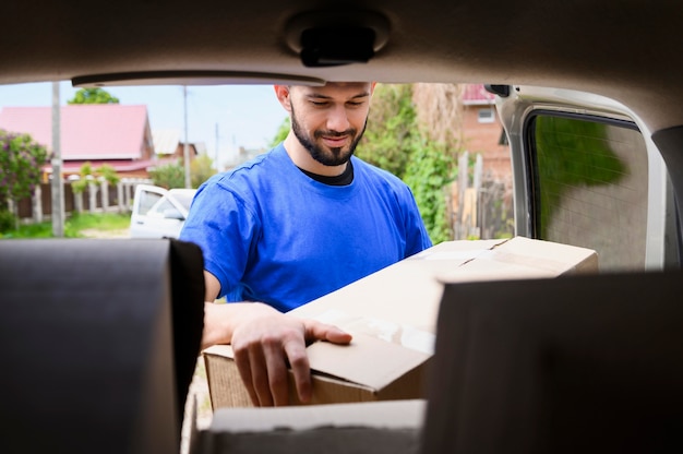 Photo bearded man taking delivery boxes out of van