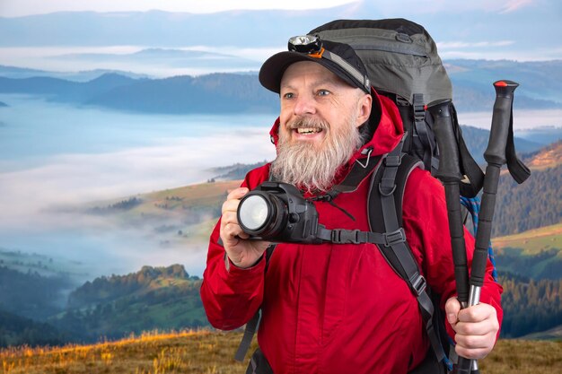 사진 수염 이 있는 남자 관광 사진작가 는 배 ⁇  을 들고 산 에서 자연 의 아름다움 을 사진 으로 찍는다