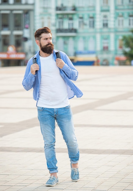 Bearded man tourist walking outside full length of caucasian tourist with beard casual tourist outdoor