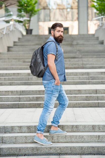 Turista uomo barbuto con zaino turistico con barba brutale turista all'aperto