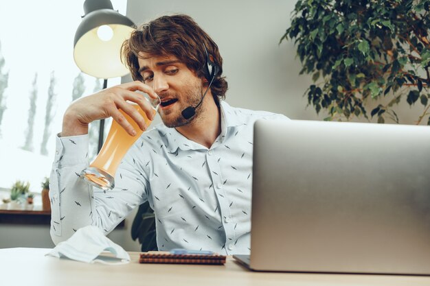 맥주 한 잔을 마시는 동안 자신의 노트북을 사용하는 수염 난된 남자