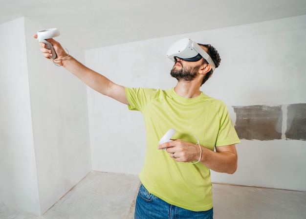 Bearded man using virtual reality goggles before starting renovations in his townhouse