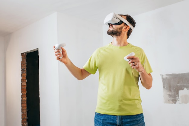 Bearded man using virtual reality goggles before starting renovations in his townhouse