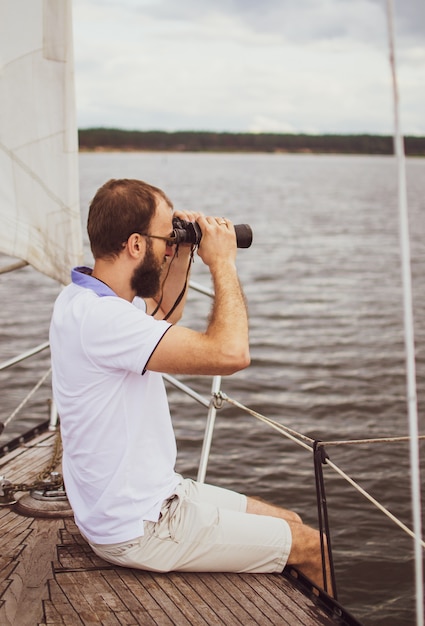 写真 ヨットで双眼鏡を見てひげを生やした男