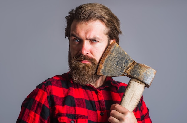 Bearded man with axe logger tool guy in checkered shirt with hatchet canadian lumberjack with ax