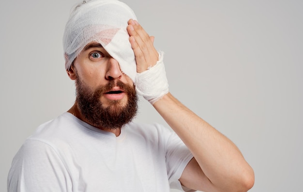 Bearded man with bandaged head and eye hospitalization hospital\
medicine