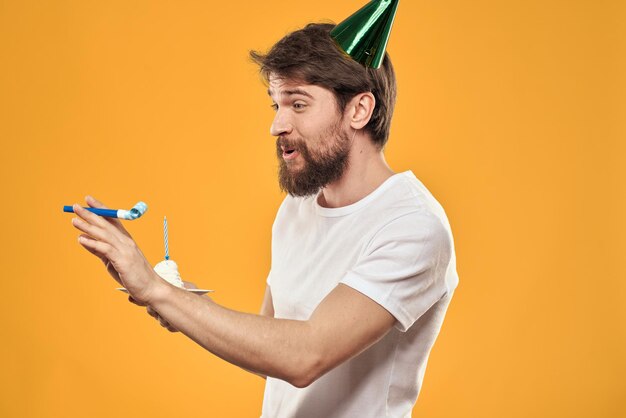 A bearded man with a cake and in a cap celebrating his birthday person