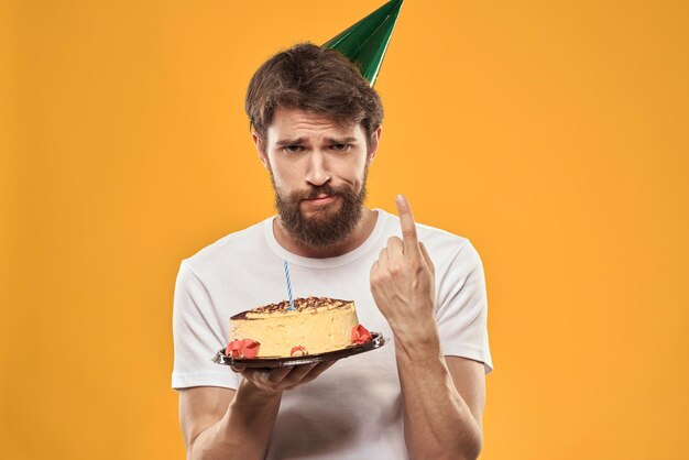 A bearded man with a cake and in a cap celebrating his birthday person