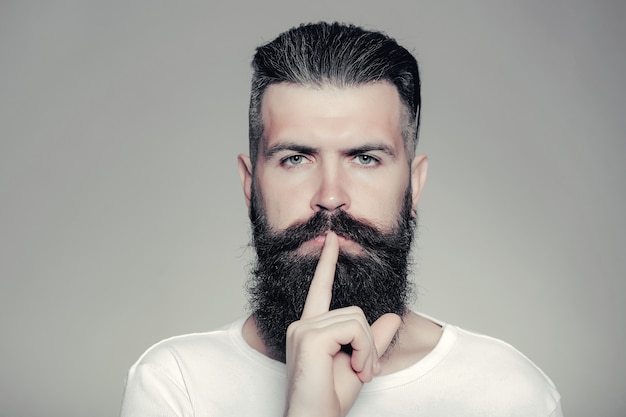 Bearded man with hush gesture