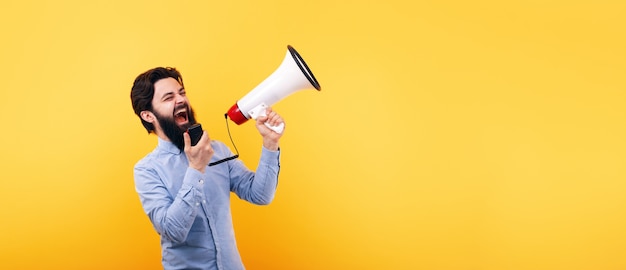 Bearded man with megaphone over yellow background