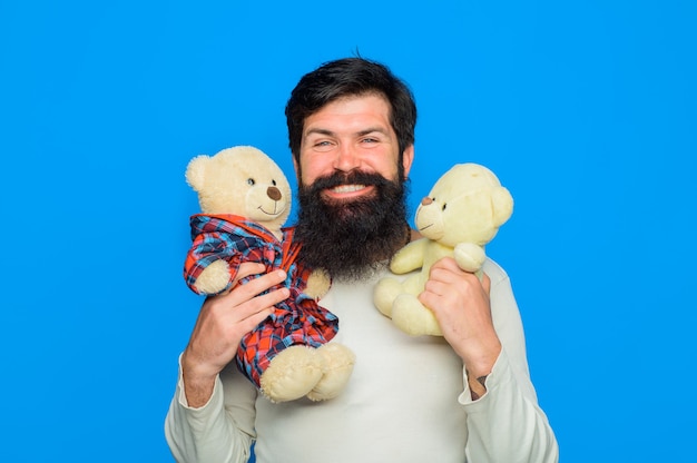 Photo bearded man with plush toy teddy bear smiling man holds teddy bears plush toy birthday or