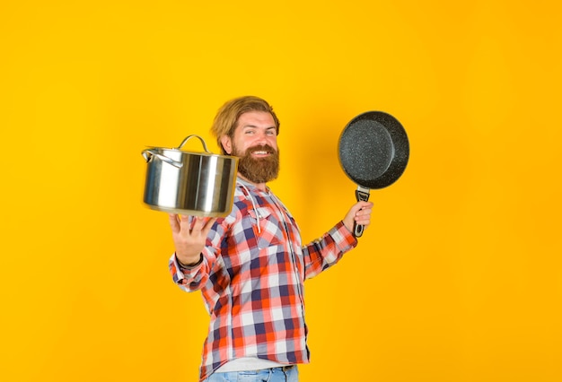 Bearded man with saucepan frypan man chef with pot saucepan cooking kitchenware cooking utensils