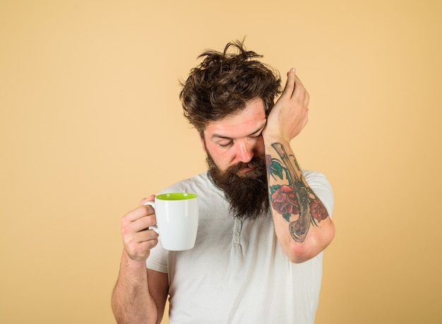 Bearded man with white coffee cup tired sleepy man with beverage in cup morning refreshment and