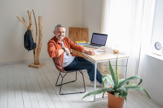 A bearded mature man sitting at the table in the office