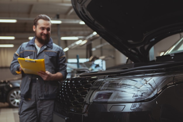 Bearded mechanic working at car service station