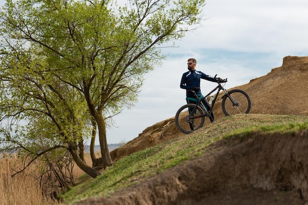 Bearded mountain bicyclist rides mountains and forest