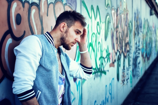 Bearded person near graffiti wall